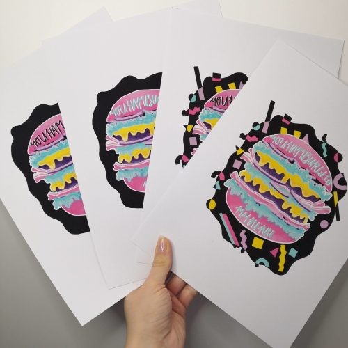 A white print with a burger in the centre, which has the phrase "you hamburgled my heart" on the bun. The bun is bright pink, and there are 80s shapes in other vivid colours beneath the burger (yellow, pink turquoise and lilac) Available in A5, A4 or A3 - pictured is the A4 size. The print is printed onto 230gsm matte photo Paper, with Recycled cardboard + Compostable See-through bags to keep them safe.